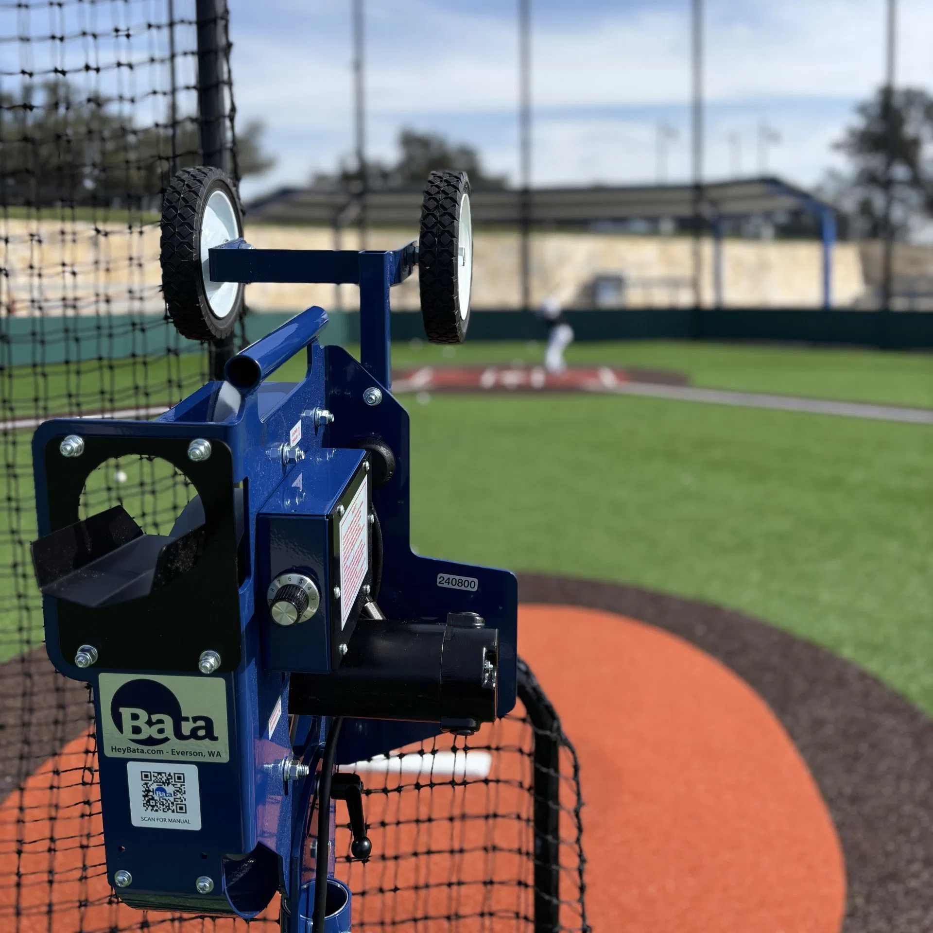 Baseball pitching machine on a baseball field ready for batting practice